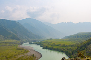 river in mountain valley, flow of water among rocks and stones with trees on shore, water tourist...