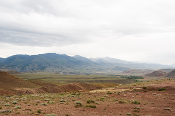 desert landscape on summer day, red hills similar to martian landscape. Soil erosion in canyon, lack of water and rain turns valley into steppe