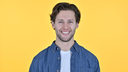 Fototapeta premium Young Man Smiling at the Camera on Yellow Background