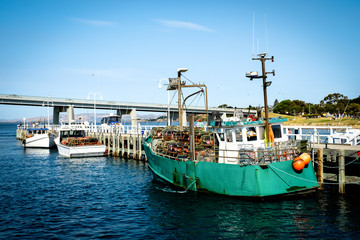 Fishing yachts parked at dock with a bridge connecting Phillip Island with San Remo area