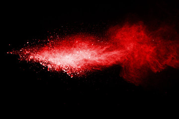 Red powder explosion on black background. Colored cloud. Colorful dust explode. Paint Holi.