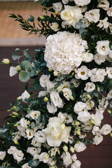 Wedding round arch decorated with a composition of fresh flowers for an outdoor wedding ceremony.