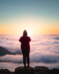 silhouette of woman at sunrise on top of a mountain social distancing hiking