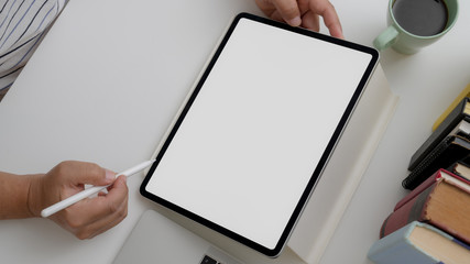 Overhead shot of male artist drawing on mock-up digital tablet on white desk