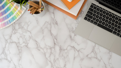 Top view of modern workspace with copy space, laptop and painting tools