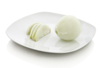 Sliced and whole onion on white ceramic plate. Isolated on white background with shadow reflection. With clipping path. With vector path. One piece of white onion with some slices near on white bg.