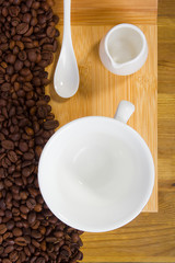 Obraz na płótnie Canvas Coffee beans and a cup with milk jug
