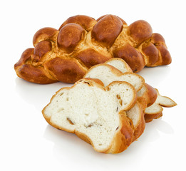 Fancy bread with raisins in slovak called: Vianocka. Sweet leavened bread slices with and one whole piece in the back. Easter bread. Isolated on white bg. with shadow reflection. With clipping path.