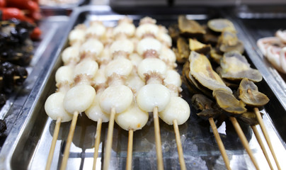 Squids on wooden sticks for grilling.