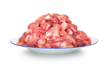Raw pork meat on the plate. Isolated on white background with natural shadow. Diced pig meat on a ceramic plate. Uncooked meat on white bg.