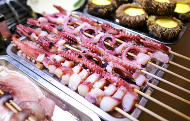 Octopus on wooden sticks for grilling.
