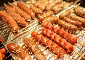 Sausages on wooden sticks for grilling.