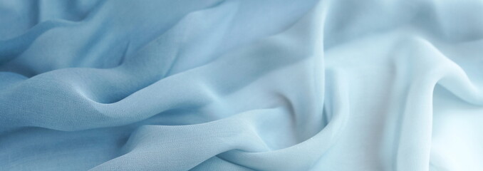 Obraz premium Silk fabric texture background pastel blue color. banner. Beautiful soft crumpled backdrop.Copy space