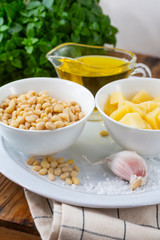 Pesto sauce ingredients on wooden table.