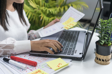 Website development startup asian designer planning wireframe mobile application layout design for web content on paperwork template, UI/UX front end / storyboard creative display in modern office