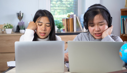 Young Asian female student study in technology using laptop and learning online, Portrait of happy watching video conference on computer, sitting learning project homework with happiness time in home