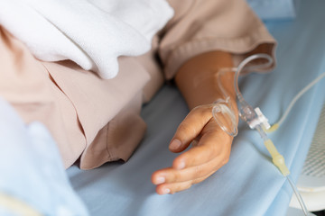 Virus treatment for Patients woman Sleep with hands medical drip intravenous needle, saline Iv drip, give salt water on hospital bed. intravenous therapy-IV is therapy delivers fluids directly in vein