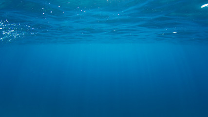 Obraz premium Underwater ocean background. Sea surface and sunlight