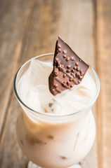 Creamy cocktail with ice and slice of chocolate. Selective focus. Shallow depth of field.