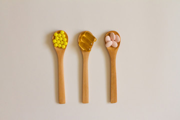 Assorted pharmaceutical medicine. Dosage. Tablets and capsules on a wooden spoon on a white background. Concept of medicine. Alternative homeopathy. Flatley. The view from the top.