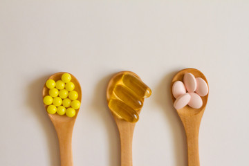 Assorted pharmaceutical medicine. Dosage. Tablets and capsules on a wooden spoon on a white background. Concept of medicine. Alternative homeopathy. Flatley. The view from the top.