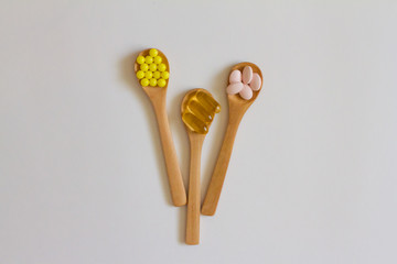 Assorted pharmaceutical medicine. Dosage. Tablets and capsules on a wooden spoon on a white background. Concept of medicine. Alternative homeopathy. Flatley. The view from the top.