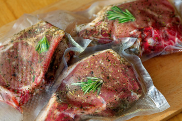 Close up of a vacuum-packed pork steak on a wooden cutting board
