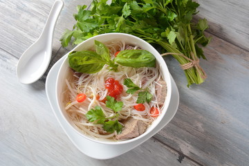 Traditional Vietnamese soup Pho bo with herbs,beef, rice noodles,chili and bean sprouts ....