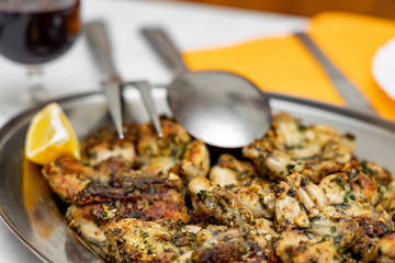Frog legs baked with garlic butter and parsley, fresh lemon and a glass of dry red wine.