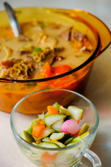 A bowl of Soto Betawi, Indonesian native traditional soup made of beef or beef offal cooked in coconut milk broth, to be eaten along with pickles
