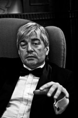 A grey-hair elderly imposing man in an interior.