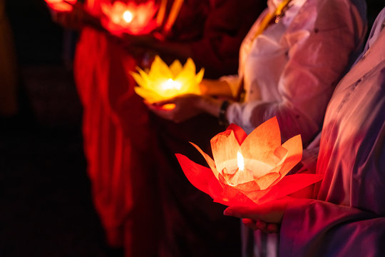 Buddhist hold lanterns and garlands praying at night on Vesak day for celebrating Buddha's birthday in Eastern culture
