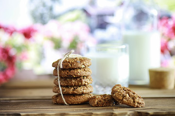 Fresh oatmeal cookies with milk on a texture wood background. Christmas gingerbread cookie and a glass of milk.