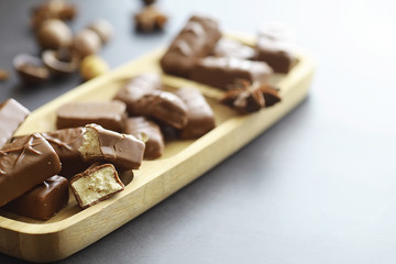 Chocolate bars on a black background in backlight. Chocolate with filling. Sweet sweets for snack and tea.