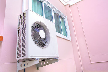 Compressors are installed on the outside wall of the building.
