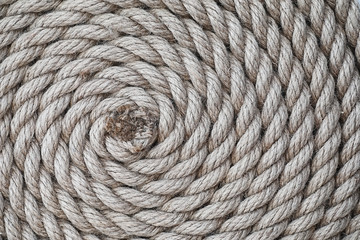 Braided thick rope tied in a skein. Hemp rope for decoration and design. Background from a fishing rope.