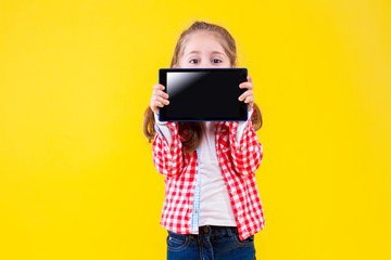 Fair haired girl is holding in hands tablet computer with empty blank screen display and hiding...