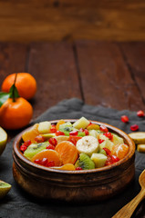 Healthy fruit salad on wood background