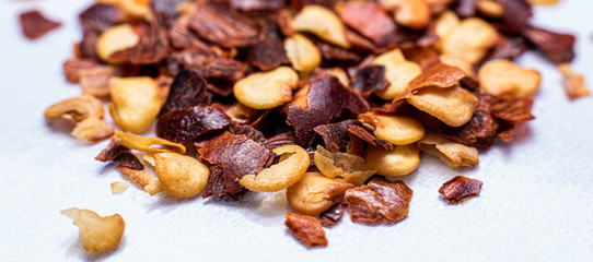 a pile of dried up chili flakes on a white background
