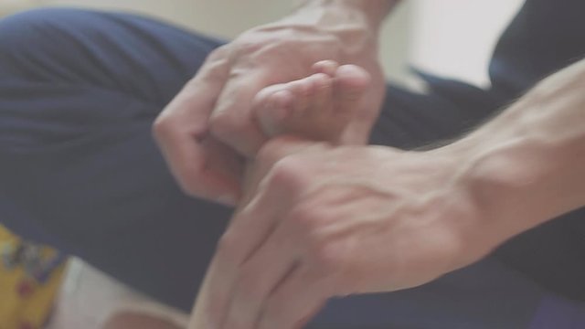 close-up mom doing foot massage to a newborn baby boy