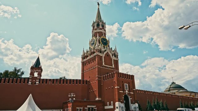 Tilt-up to reveal the imposing Spasskaya Tower (Saviour Tower) on the eastern wall of Moscow's Kremlin against a blue sky backdrop