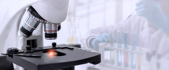 Laboratory concept; close up of microscope with a blurred picture of the scientist is researching...