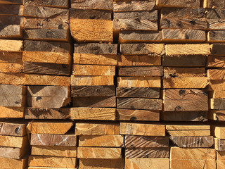 Stack of lumber at the outdoor warehouse. Stockpiled edged boards