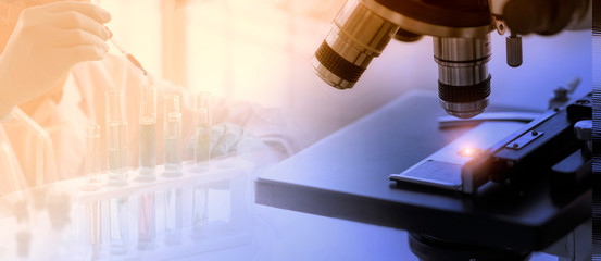 Laboratory concept; close up of microscope with a blurred picture of the scientist is researching in laboratory