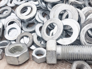 Steel nuts, bolts and washers piled in the box. Fastening construction equipment