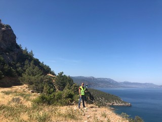 Geodetic engineer surveyor in white hard hat doing measurements with GNSS satellite receiver at the...