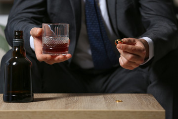 Divorced man drinking cognac at home. Concept of alcoholism