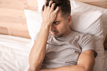 Depressed young man in bedroom