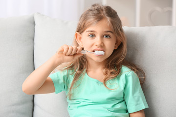 Cute little girl with toothbrush at home