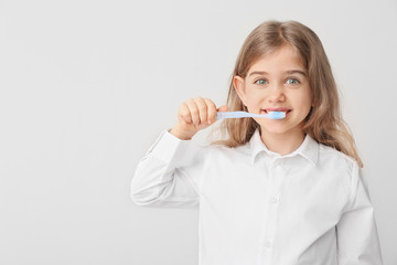 Cute little girl with toothbrush on white background